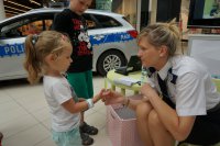 Policjantka w trakcie wręczania dziecku odblasku