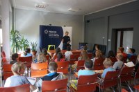 Sierżant Monika Śliwińska prezentuje dzieciom wyposażenie policjanta